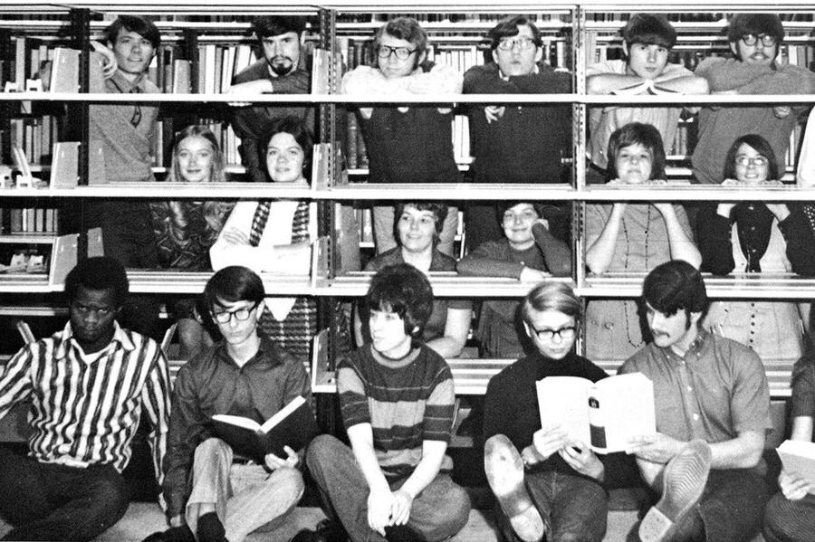 照片拍摄于1971年，学生们站在图书馆书架前和书架后.